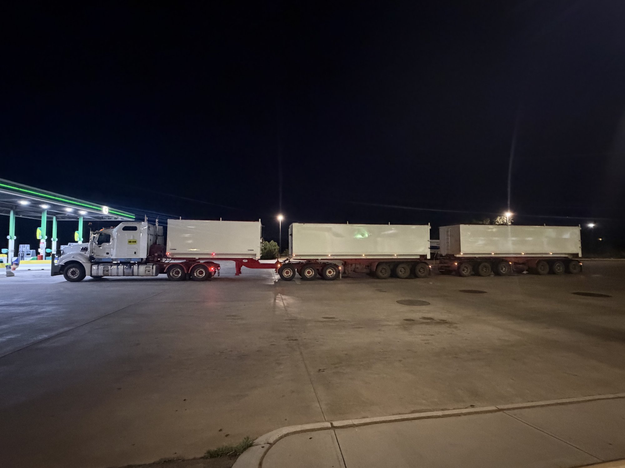 BJ Group Mack prime mover with three tipper trailers at night